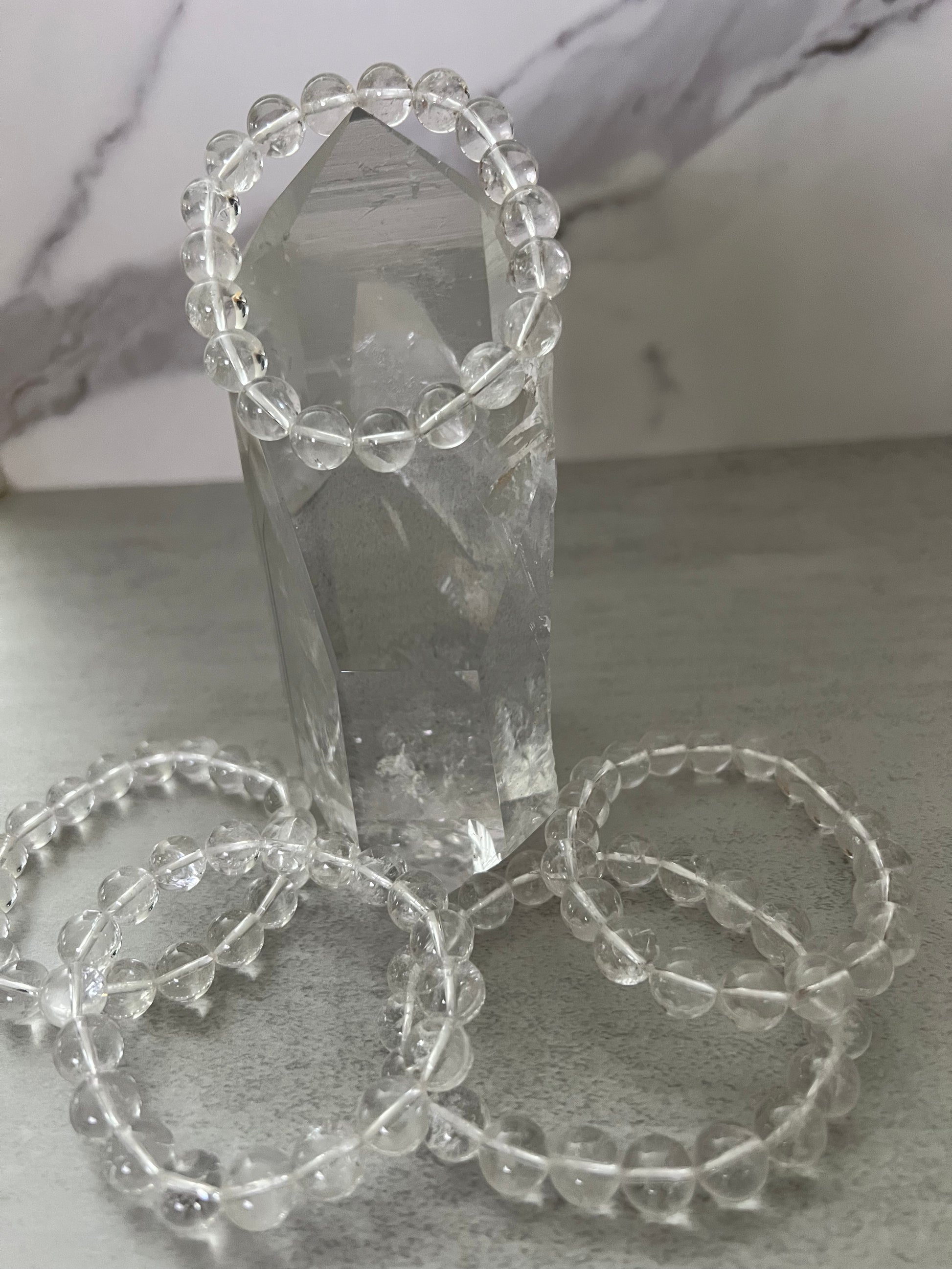 Crystal tower with beaded bracelets on a light gray surface