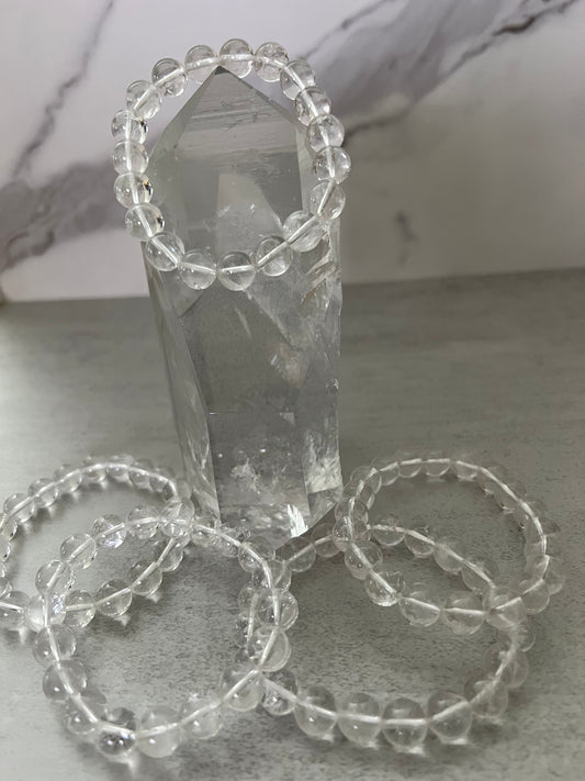 Crystal tower with beaded bracelets on a light gray surface