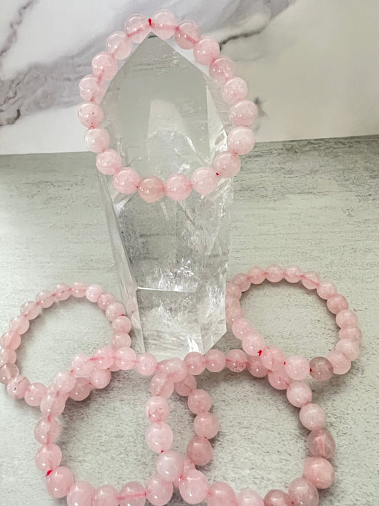 Set of pink beaded bracelets on a marble surface