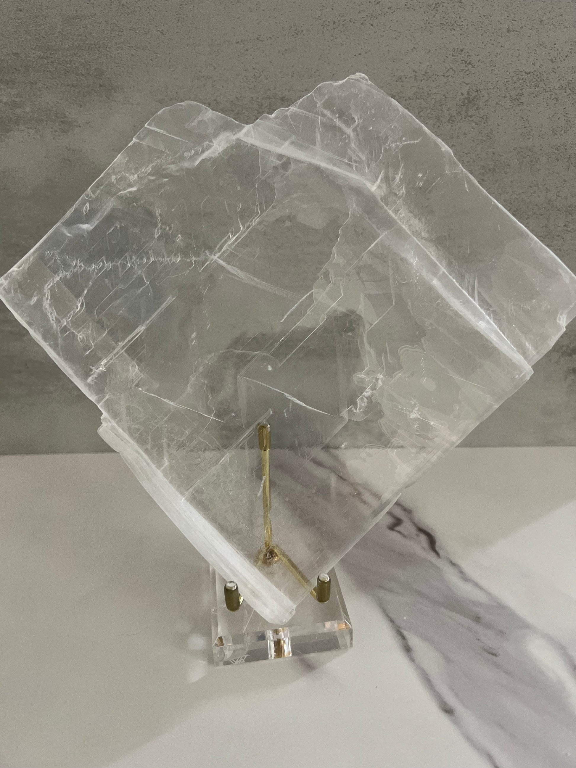 Clear slab on a gold stand on a gray background