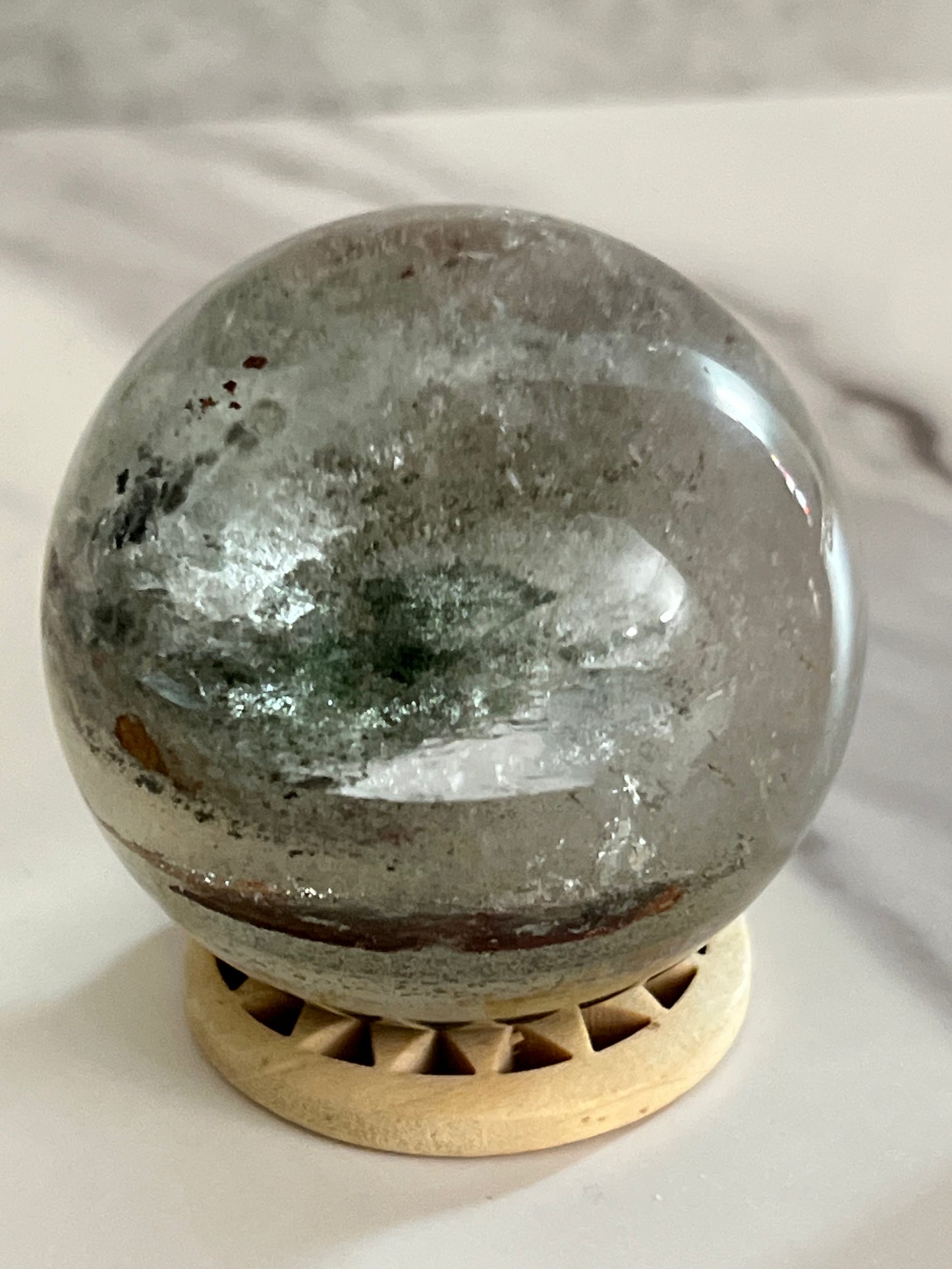 Crystal ball with a metallic sheen on a white surface